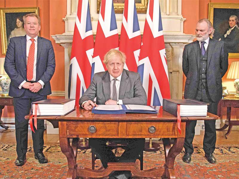 رئيس الوزراء بوريس جونسون موقّعاً اتفاق «الانفصال» أمس الأول    (أ ف ب)