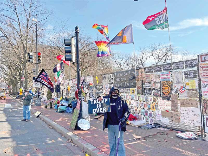 متظاهر يحمل لافتة كتب عليها «ترامب انتهى» في واشنطن أمس الأول    (أ ف ب)