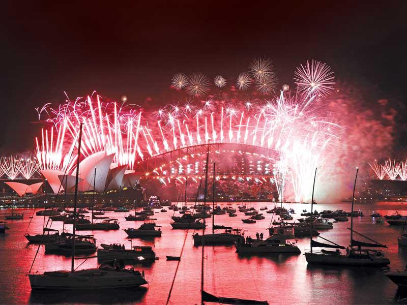 انطلاق الألعاب النارية احتفالاً بـ2021 فوق دار أوبرا وجسر ميناء سيدني أمس (رويترز)