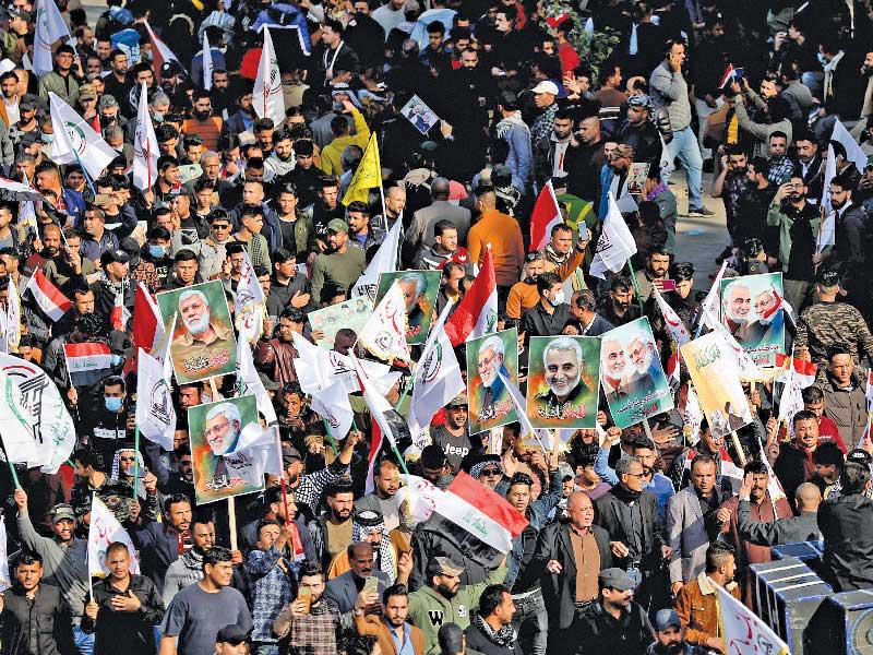 عراقيون يشاركون بمسيرة في الذكرى الأولى لمقتل سليماني والمهندس في بغداد أمس 	 (إي بي إيه)