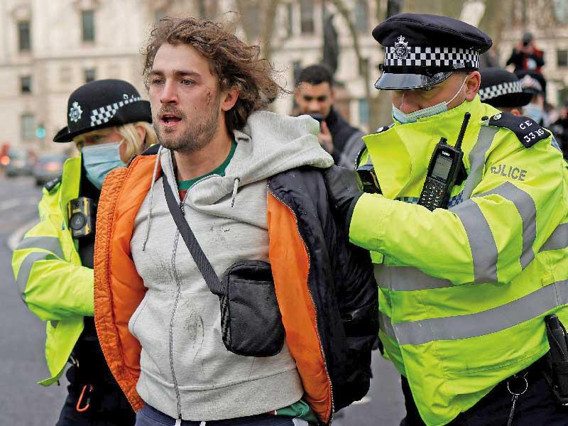 الشرطة تعتقل متظاهراً يحتج على اجراءات العزل في لندن أمس (ا ف ب)
