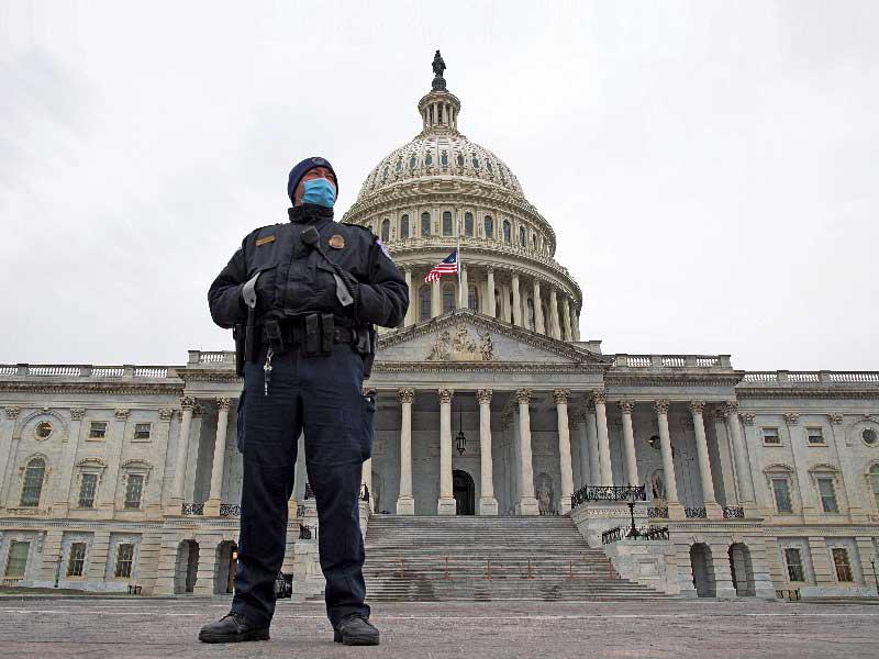 شرطي يحرس مبنى الكابيتول بواشنطن... وفي الإطار حساب ترامب مغلق من قبل «تويتر» t(إي بي أيه)