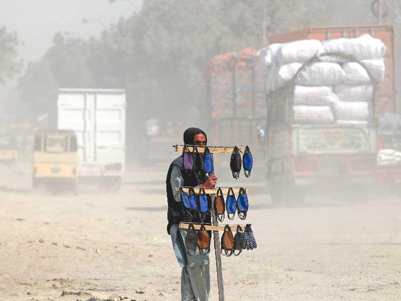 باكستاني يعرض كمامات للبيع في كراتشي أمس (اي بي ايه)