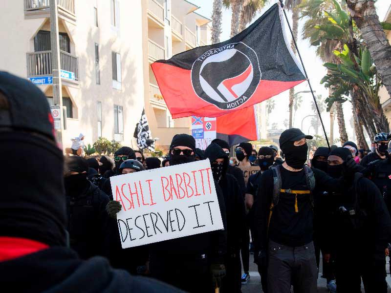 أنصار منظمة «انتيفا» اليسارية المتشددة في سان دييغو بكاليفورنيا، يرفعون لافتة كتب عليها «اشلي بابيت تستحق»، في إشارة إلى مؤيدة ترامب التي قتلت برصاص الشرطة خلال اقتحام الكونغرس  (أ ف ب)