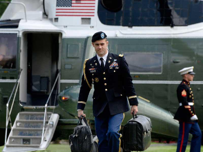 ضابط أميركي يحمل حقيبة الرموز النووية خلال الترجل من المروحية الرئاسية 
