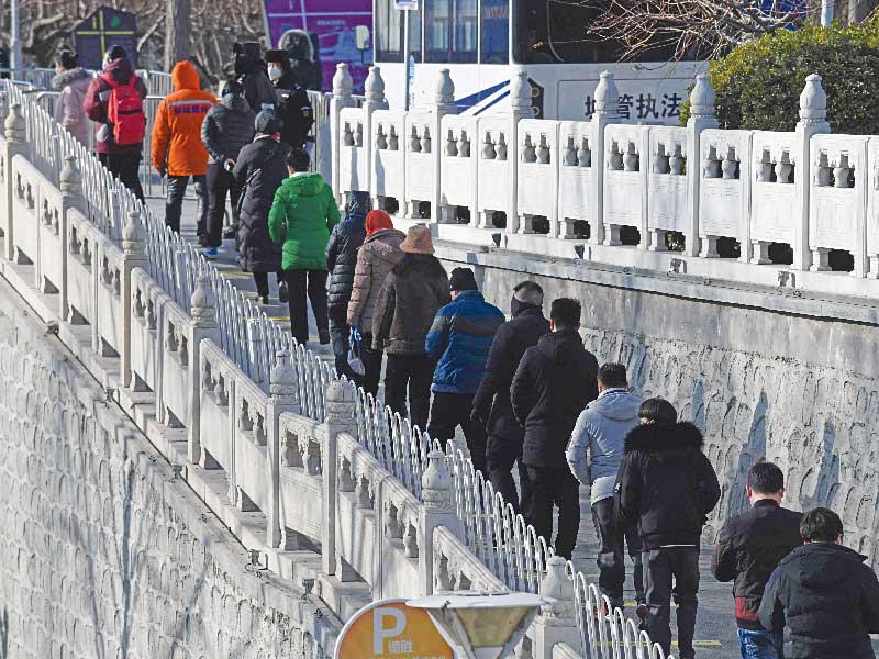 مواطنون صينيون ينتظرون في الصف لإجراء فحص «كورونا» في بكين أمس (أ ف ب)