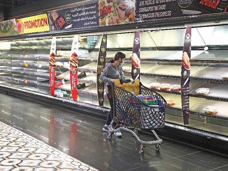 لبنانية أمام أرفف فارغة في إحدى الجمعيات عشية الإغلاق الشامل لاحتواء تفشي «كورونا»  (رويترز)