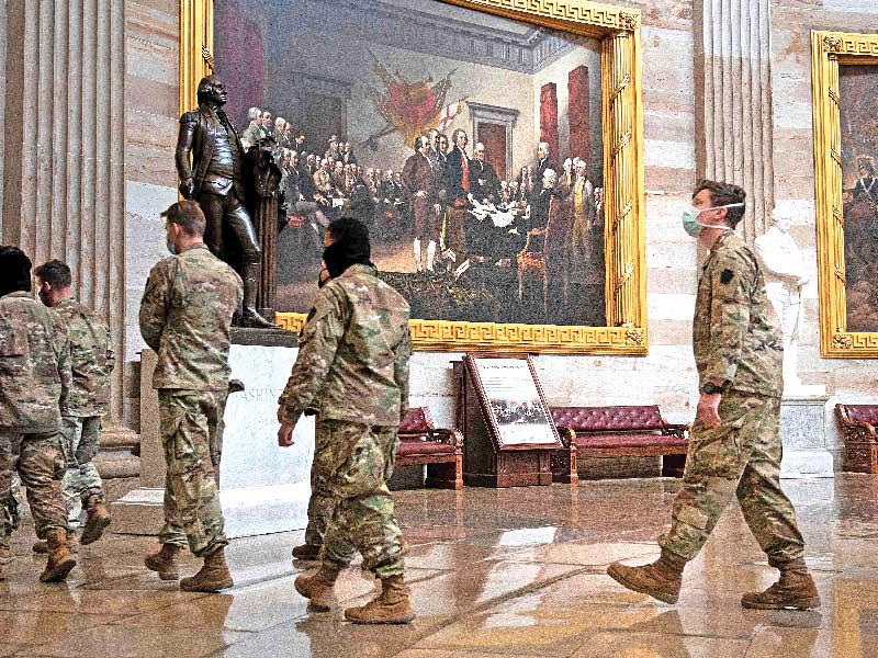 عناصر الحرس يمرون أمام لوحة الاستقلال لحراسة مبنى الكابيتول هيل أمس الأولt(أ ف ب)