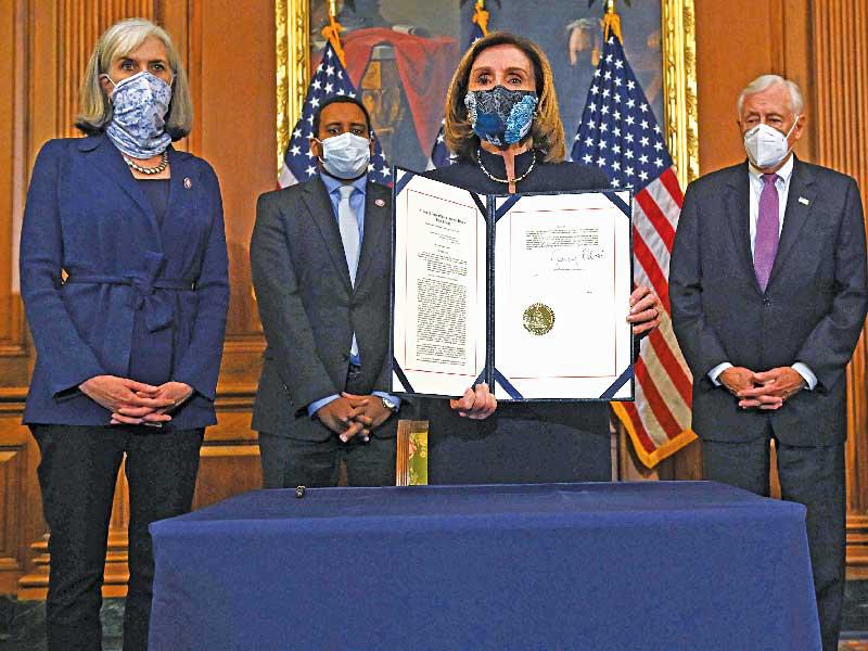  رئيسة مجلس النواب نانسي بيلوسي تحمل قرار إحالة ترامب للمحاكمة في الكابيتول أمس الأولt (أ ف ب) 