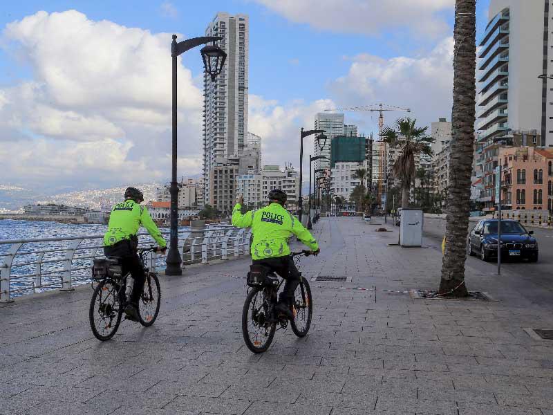 شرطيان على دراجتين خلال دورية على الكورنيش البحري في بيروت مع استمرار سريان الإقفال العام (إي بي أيه)