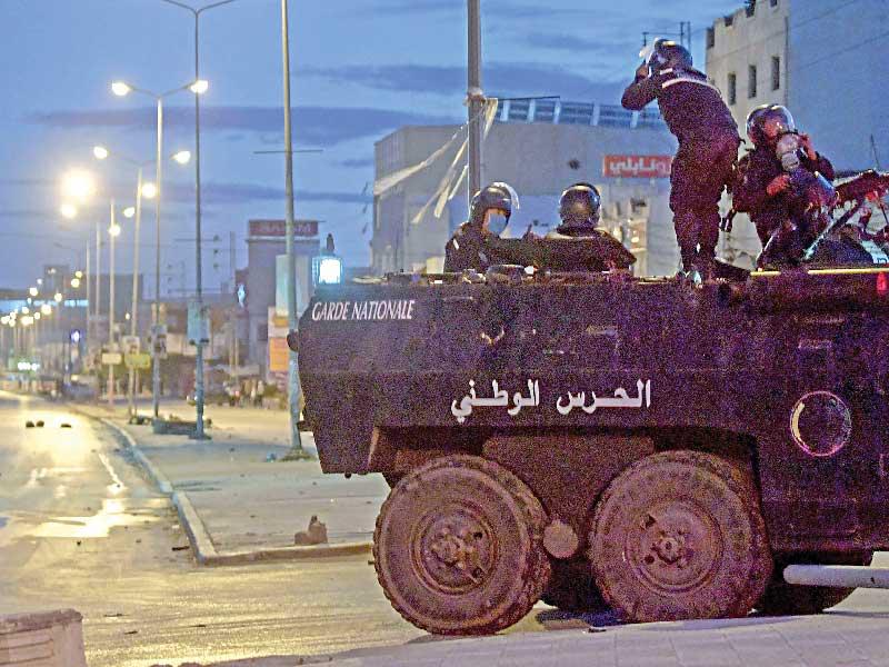 آلية للحرس الوطني في أحد شوارع العاصمة التونسية خلال تجدد الاشتباكات مساء أمس الأول         (أ ف ب)