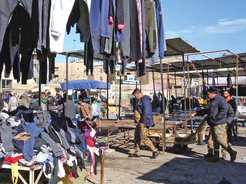 بدء عودة الحياة إلى سوق الملابس المستعملة قرب ساحة الطيران وسط بغداد أمس (أ ف ب)