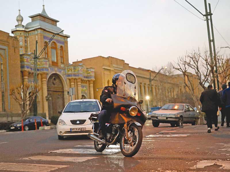 إيراني على دراجته النارية في وسط طهران أمس الأول  (رويترز)