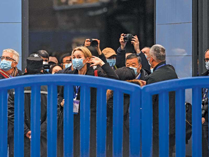 محققو الأمم المتحدة في سوق ووهان للحيوانات البحرية بالصين أمس (أ ف ب )