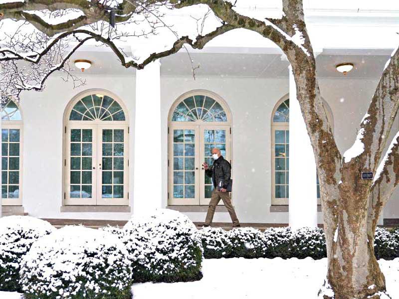 الرئيس الأميركي جو بايدن يحمل ملفاته وسط الثلوج في البيت الأبيض أمس (حساب الرئيس)