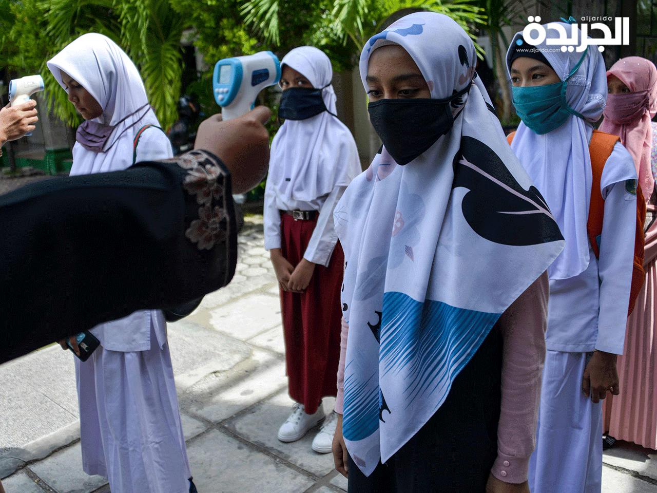 فحص حرارة الفتيات قبل دخولهن إلى المدارسى مع التزامهن بالحجاب في إقليم  بادانجn