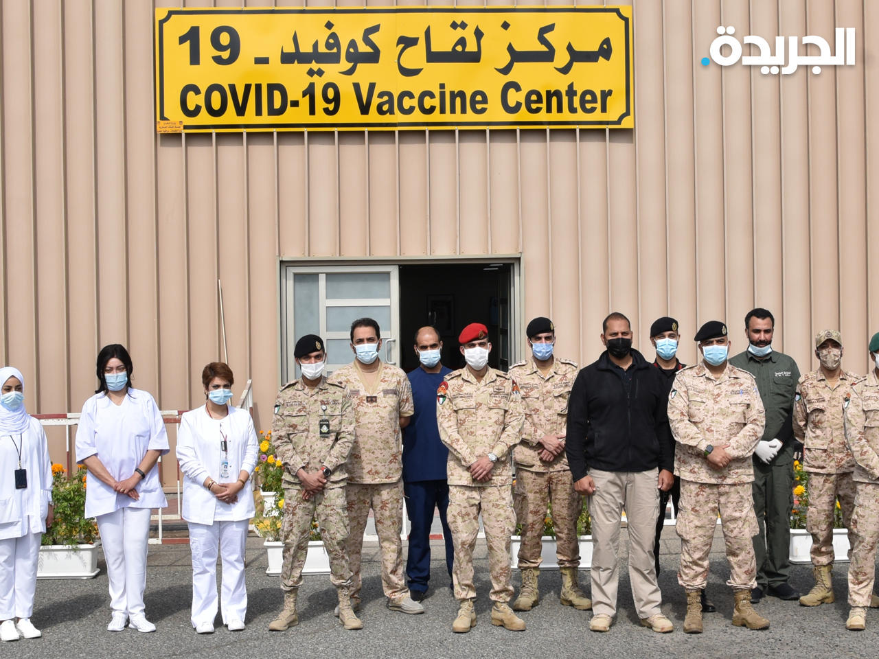 العاملون أمام مركز التطعيم 