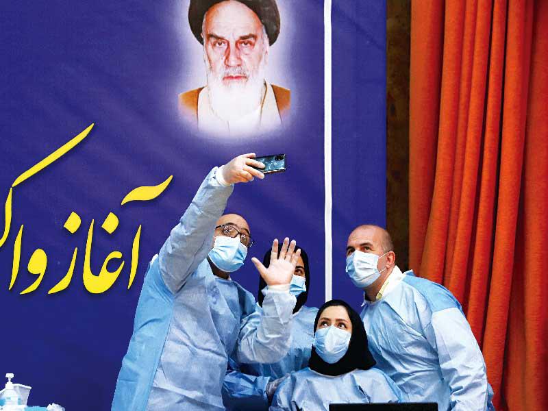 أعضاء طاقم طبي إيراني يلتقطون «سيلفي» مع بدء التطعيم باللقاح الروسي (رويترز)n