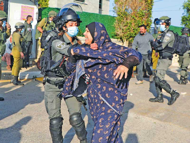 شرطية إسرائيلية تعتدي أمس على فلسطينية في جنين خلال هدم منزل فلسطيني نفذ هجوماً (أ ف ب)