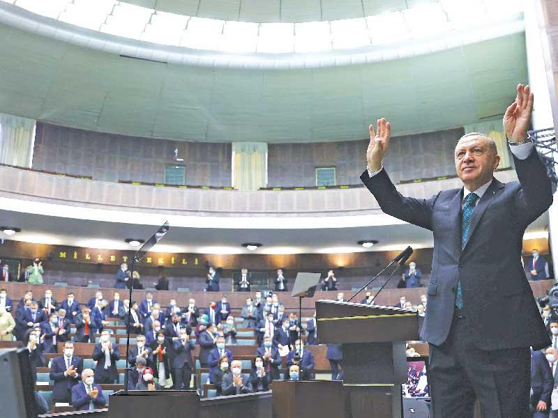 الرئيس التركي رجب طيب إردوغان يحيي نواب حزبه في البرلمان أمس (رويترز)