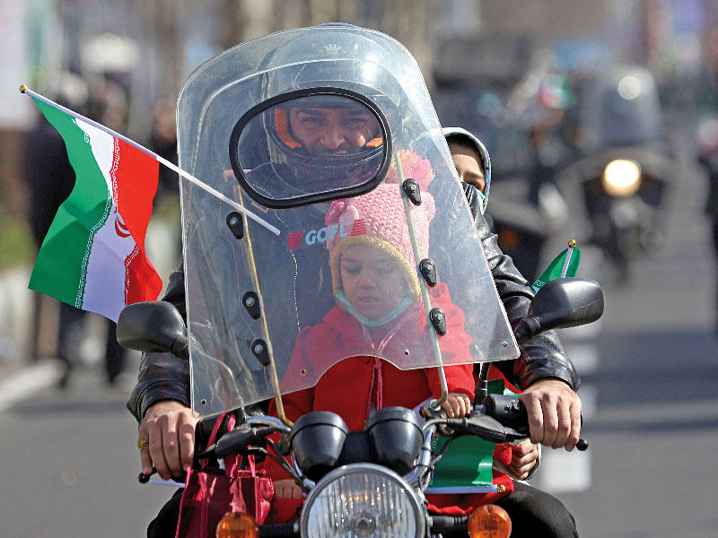 عائلة إيرانية على دراجة خلال احتفالات بذكرى الثورة في طهران  (رويترز)