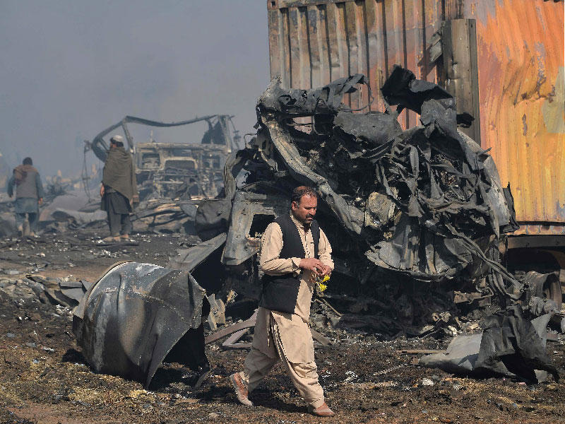 أفغاني في موقع الحريق الكبير على المعبر الحدودي الأفغاني ـ الإيراني (أ ف ب) 