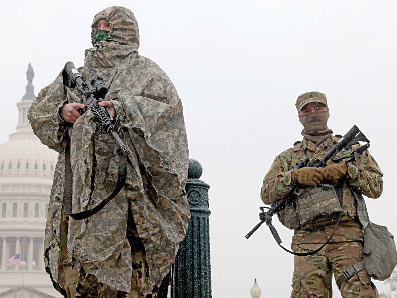 عنصران من الحرس الوطني يحرسان «الكابيتول» قبل انتهاء جلسة محاكمة ترامب أمس الأول وسط طقس عاصف (أ ف ب)