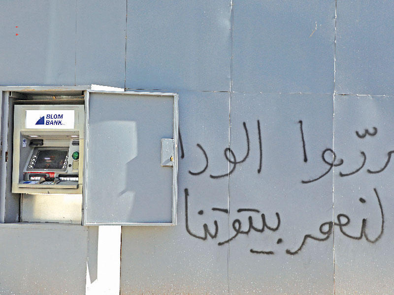 ماكينة سحب آلي مصفحة خارج أحد مصارف بيروت حيث كتبت عبارة «حرروا الودائع لنعمر بيوتنا» في إشارة الى احتجاز المصارف ملايين الدولارات من الودائع بسبب الأزمة المالية (رويترز)
