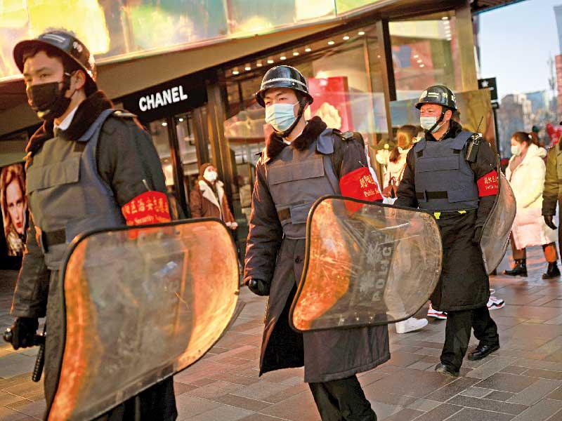 عناصر أمن في شوارع بكين خلال الاحتفالات بعيد رأس السنة القمري أمس (رويترز)