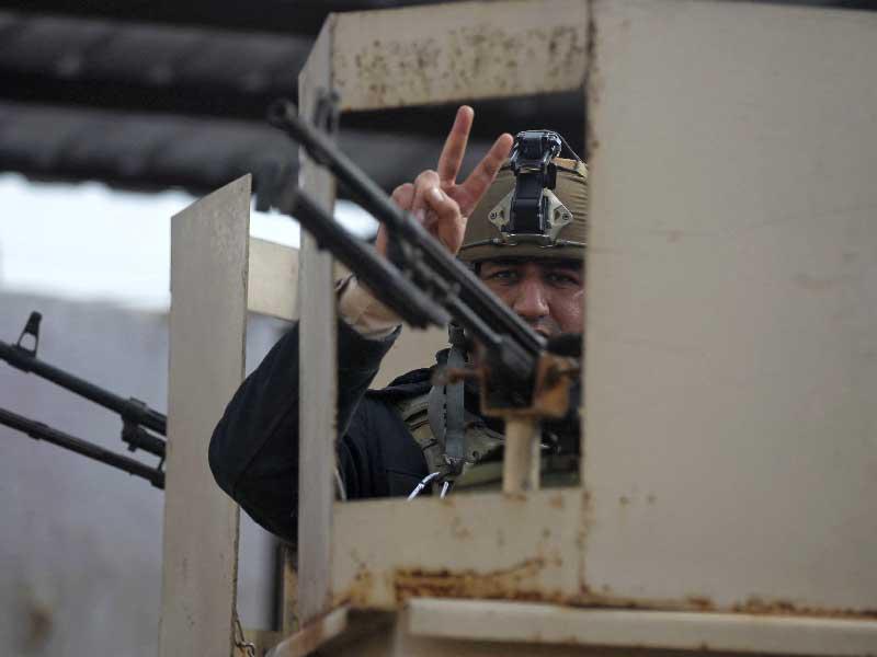 جندي عراقي يرفع شارة النصر خلال العمليات في الطارمية أمس الأول (أ ف ب)