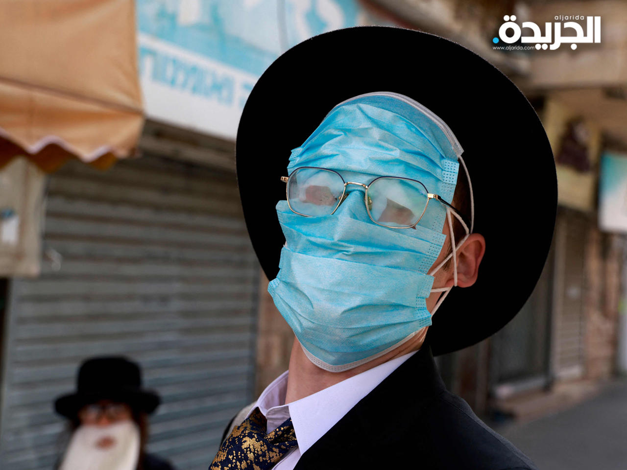 شاب إسرائيلي يرتدي عدة أقنعة للوجه خلال احتفالات عيد المساخر في القدس