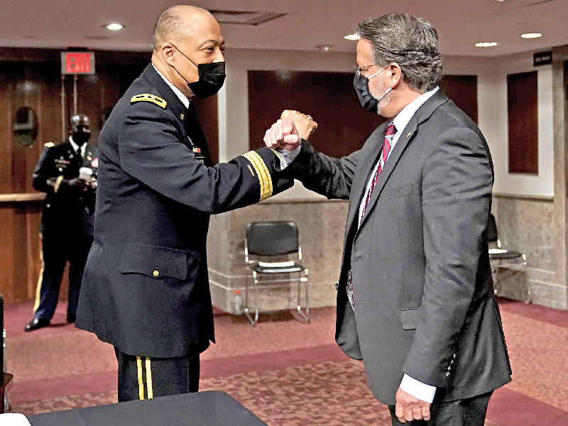 قائد الحرس الوطني بمنطقة كولومبيا وليام ووكر يتبادل التحية مع السناتور غاري بيترز قبل الاستماع لشهادته بمجلس الشيوخ أمس الأول (إي بي إيه)