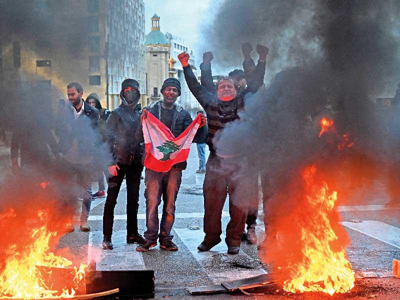 لبنانيون يقفلون طريقاً بالإطارات المشتعلة في بيروت t(اي بي ايه)