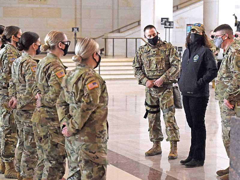 حاكمة ميشيغان مع عناصر الحرس الوطني بقاعة زوار الكابيتول أمس الأول (أ ف ب)