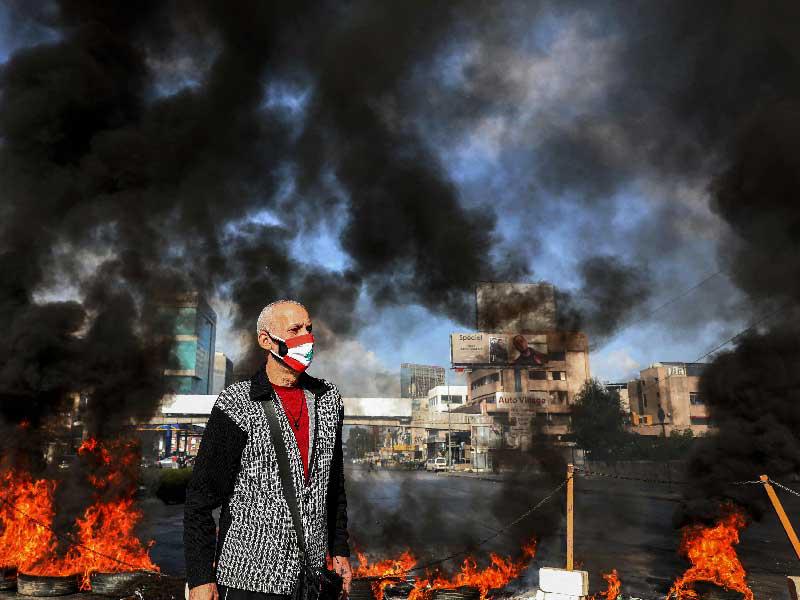 لبناني  قرب اطارات مشتعلة في منطقة الزوق أمس