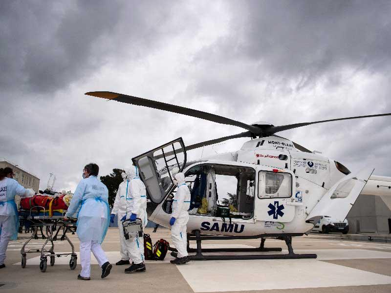 مسعفون ينقلون مريضاً بـ «كوفيد 19» من مستشفى بواسطة مروحية في فرنسا أمس (أ ف ب)