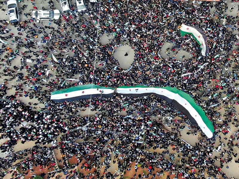 معارضون يحيون ذكرى انطلاق الحرب السورية قبل عشر سنوات في إدلب أمس (رويترز)n