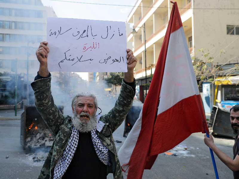 متظاهرون مناهضون للحكومة يغلقون الشارع  مع مكب نفايات محترقة