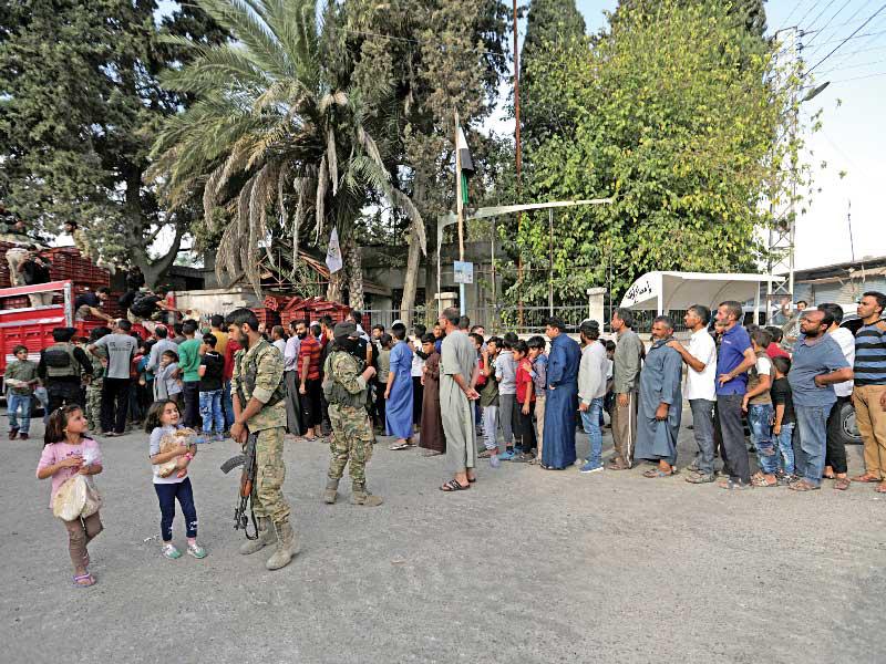 سوريون ينتظرون في طابور للحصول على خبز في تل أبيض 