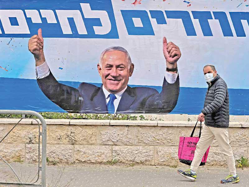 إسرائيلي يمر أمام لافتة انتخابية لنتنياهو في القدس أمس         (أ ف ب)