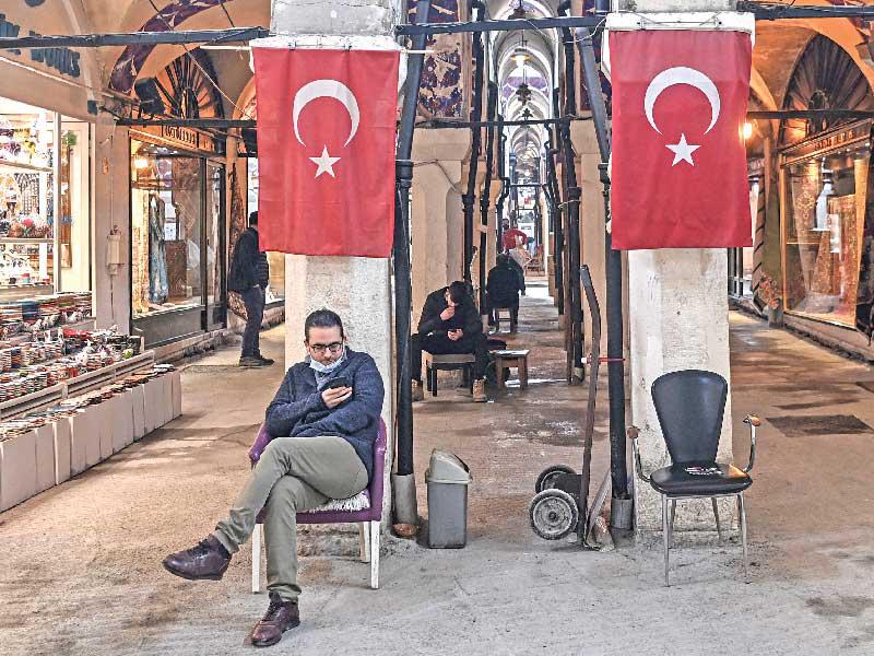 بائع تركي ينتظر الزبائن أمام محلّه في البازار الكبير في إسطنبول أمس (ا ف ب)