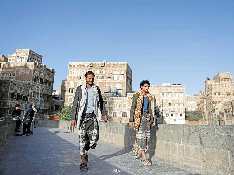 يمنيان يسيران في أحد احياء صنعاء القديمة أمس (رويترز)