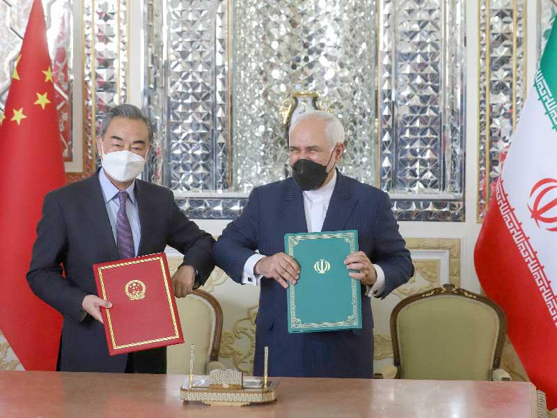 وزير الخارجية الإيراني محمد جواد ظريف ونظيره الصيني وانغ يي عقب توقيع الاتفاقية في طهران أمس (رويترز)