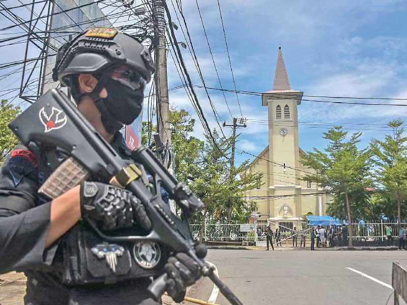 جندي إندونيسي امام الكنيسة المستهدفة في مكاسار أمس (أ ف ب )