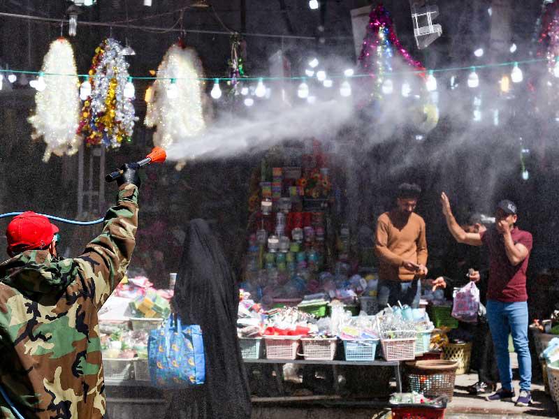 جندي يعقم سوقاً شعبياً في كربلاء أمس  (أ ف ب)