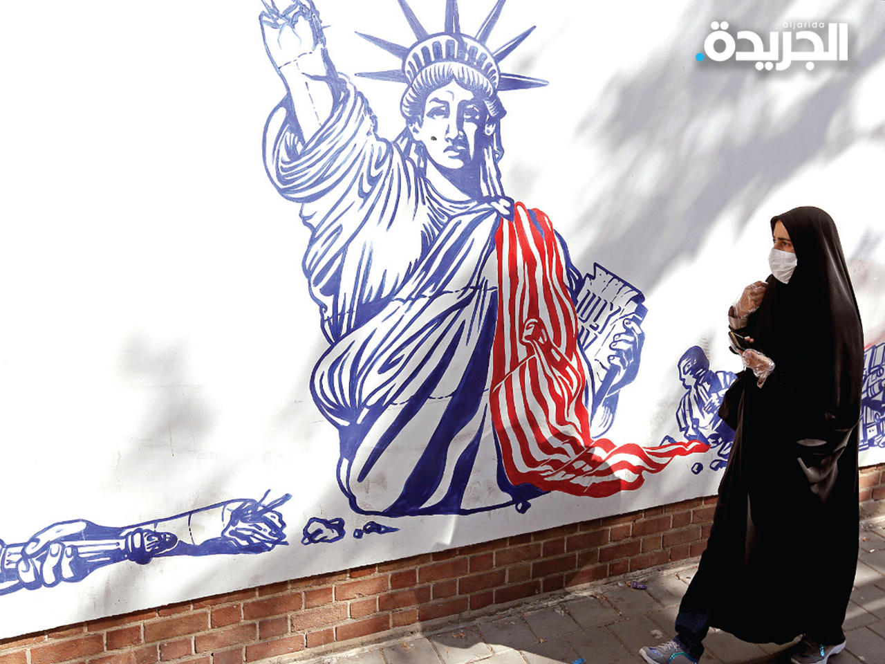 إيرانية تمر قرب جدارية لتمثال الحرية الأميركي