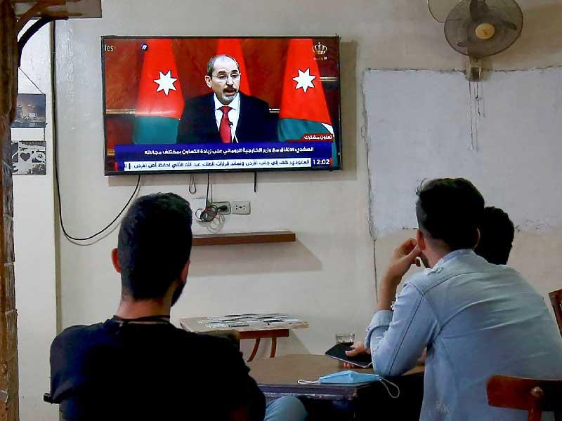 أردنيون يتابعون التطورات السياسية الأخيرة في بلادهم عبر شاشة تليفزيونية في مقهى بالعاصمة عمان