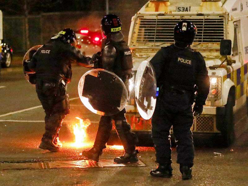 عناصر من الشرطة بعد رميهم بقنبلة حارقة في بلفاست مساء أمس الأول (رويترز)