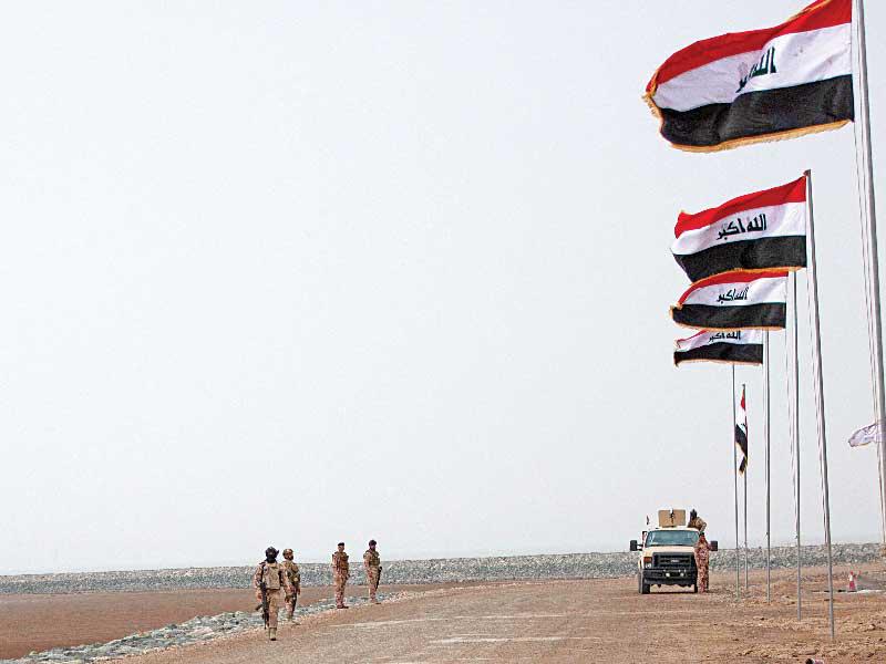 قوة أمنية عراقية خلال زيارة الكاظمي إلى الفاو أمس (أ ف ب)