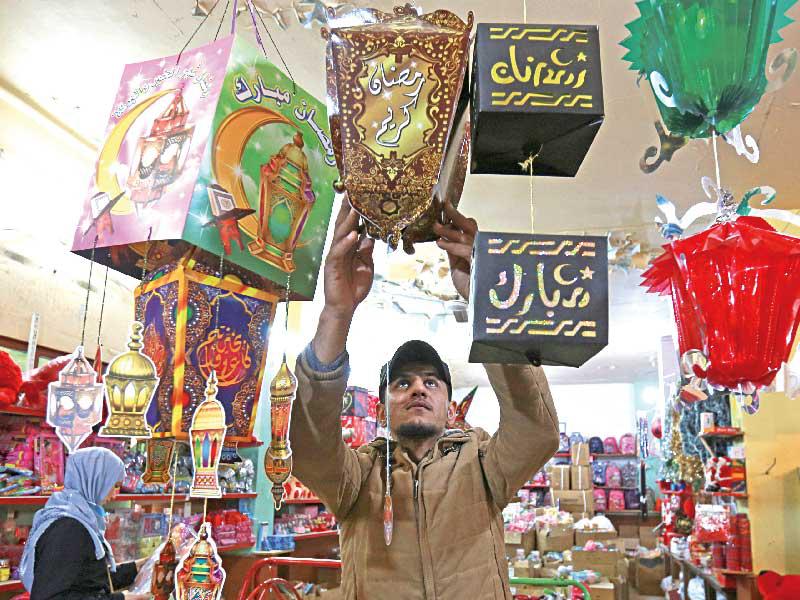 بائع يجهّز محلّه في مدينة صيدا الجنوبية استعداداً لبداية رمضان  (رويترز)